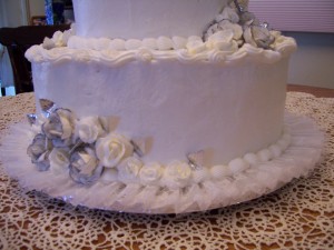 A white cake with silver flowers on top of it.